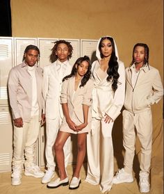 a group of young people standing next to each other in front of lockers wearing all white