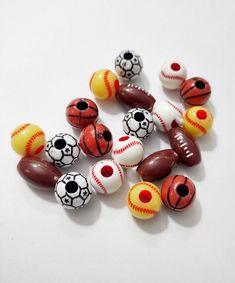 a bunch of beads that are sitting on a white surface with one ball in the middle