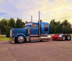 a blue semi truck parked in a parking lot