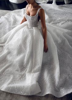 a woman in a white dress sitting on a bed