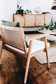 a wooden chair sitting on top of a hard wood floor next to a coffee table