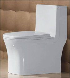 a close up of a toilet in a room with tile flooring and walls behind it