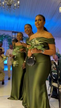 two women in green dresses standing next to each other