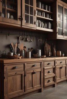 a kitchen with wooden cabinets and lots of utensils on the counter top in front of it