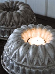 two lit candles sitting on top of cake pans