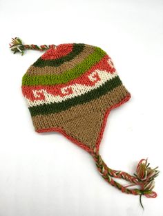 a knitted hat with red, green and white designs on the brimming