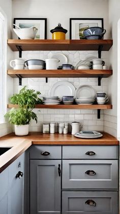 a kitchen with gray cabinets and shelves filled with plates, bowls and pans on top of them