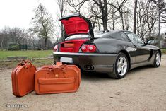 two suitcases are sitting next to a car