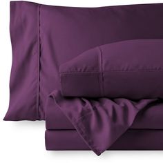 a bed with purple sheets and pillows on top of each other, in front of a white background