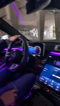 the interior of a car with blue and purple lights