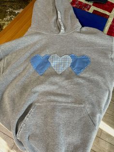 a gray hoodie with two blue hearts on it