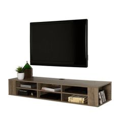 a flat screen tv mounted to the side of a wooden entertainment center with shelves below it