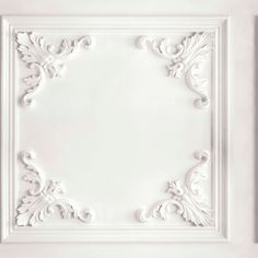 a white ceiling tile with an ornate design on the top and bottom part of it