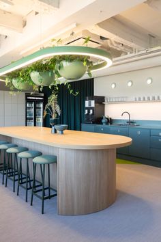 a kitchen with an island and several stools in front of the counter top that has plants growing on it