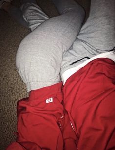 a person is laying on the floor with their feet up and wearing red sweatpants