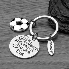 a key chain with a soccer ball on it and the words she be loved so she did