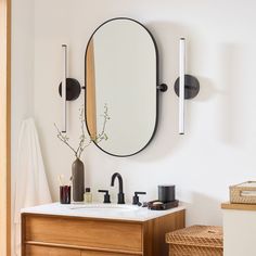 a bathroom with a sink, mirror and other items on the counter top in front of it