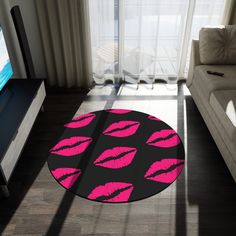 a living room with a couch, television and rug that has pink lips on it