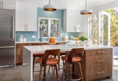 a kitchen with two bar stools and an island in front of the countertop