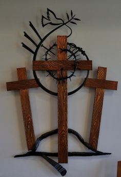 a wooden cross hanging from the side of a wall