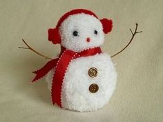 a white stuffed snowman with a red scarf around it's neck