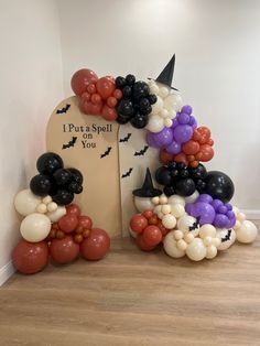 balloons are arranged in the shape of bats and pumpkins on a tombstone with a sign that says put s spell on you