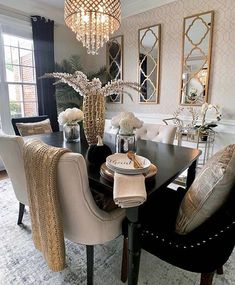 a dining room table with chairs and a chandelier hanging from it's ceiling