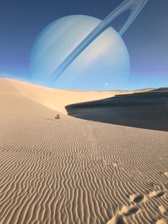 an artist's rendering of saturn and its moon in the distance, as seen from sand dunes