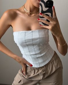 Step up your fashion game with our Irina Tube Corset Top! This stylish piece features a contrast stitch design and a convenient back zipper for easy wear. Perfect for any occasion, this top will elevate your look and get you compliments wherever you go! More Details: - Fits true to size - Does stretch - Back zipper - 74% Rayon 22% Nylon 4% Spandex - Color may vary due to the lighting - Model is wearing a size small Trendy Tops With Zipper Closure For Spring, Trendy Spring Tops With Zipper Closure, White Summer Tops With Zipper Closure, White Zipper Closure Top For Summer, Trendy Summer Tops With Contrast Stitching, Casual Fitted Tops With Contrast Stitching, Trendy Fitted Top With Contrast Stitching, Summer Stretch Tops With Back Zipper, Trendy Tops With Contrast Stitching For Spring