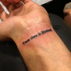 a person with a small tattoo on their wrist that says your time is limited,