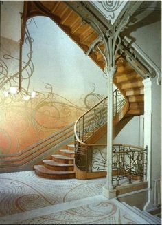 a spiral staircase with wrought iron railing and wood handrails in an ornately decorated room