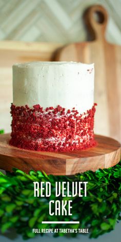 red velvet cake with white frosting and sprinkles on a wooden cutting board