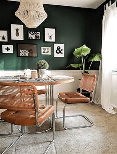 a dining room with green walls and pictures on the wall