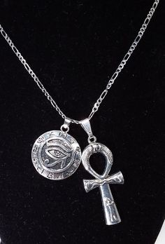 Silver Plated Ankh & Eye of Horus Duo Charm NecklaceChoose YOUR chain!Large Ankh Charm measures 1.75 inches highAnkh is 0.75 inches wideStainless Steel--with Silver PlatingEye of Horus charm is 30 mm about the size of a USA Quarter.Horus charm is hollow on backside.Choose your chain from our pull-down menu above:A } a 925 Sterling Silver Rope chain2mm wide by 45 cm long (about 17.6 inches)ORb} a Silver Figaro Chain 2mm/ 20 incheswith lobster clasp.Eco-Gift packaged.USA shipping same day as o Unisex Christmas Gifts, Protection Amulet, Eye Of Horus, Charm Necklace Silver, Red Jewelry, Tree Pendant, Silver Necklaces, Charm Necklace, Valentine Gifts