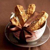 some kind of food in a bowl on a plate with a brown bow around it