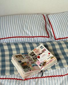 a stack of books sitting on top of a blue and white checkered comforter