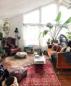 a living room filled with lots of furniture and plants on top of the couches