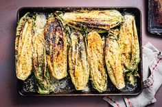 grilled corn on the cob in a baking dish with parmesan cheese