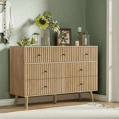 a wooden dresser sitting next to a green wall