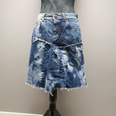 a woman's jean skirt with fraying on the front and back, sitting on top of a mannequin