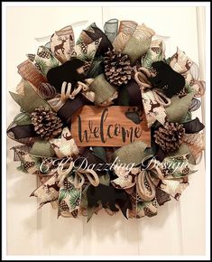 a welcome wreath with pine cones and ribbons hanging on the front door for someone to welcome