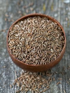 a wooden bowl filled with seeds on top of a table