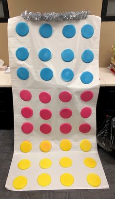 a giant board game made out of white paper with blue, yellow and pink circles