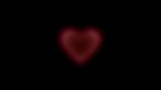 a heart shaped object in the dark with red light coming from it's center