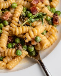 a white plate topped with pasta and peas