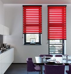 a modern kitchen with purple chairs and red blinds