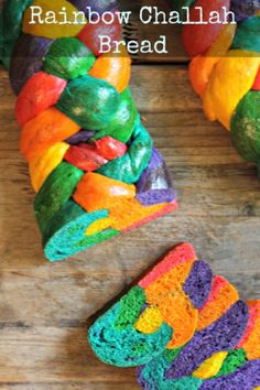 a close up of a rainbow colored bread on a wooden surface with the words rainbow challah bread