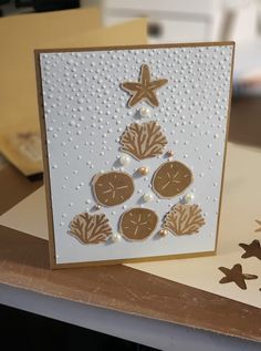 a card that has been made to look like a christmas tree with starfish and seashells