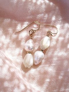 These asymmetrical carved Pikake and Baroque Pearl Earrings make beautiful simple statements. Seemingly plucked straight from the ocean, the luminous, organic white pearls sway and illuminate in the light. Wear these unique pearl, pikake, and gold earrings for a modern upgrade.✦ DETAILS ✦✧ Name: Huali - (hoo A lee) - Pure, bright, gleaming.✧ 14kt Gold Filled.✧ Genuine Freshwater Baroque Pearls.✧ Carved Mother of Pearl Pikake Flowers.✧ All Ke Aloha Jewelry pieces come packaged thoughtfully, beaut Flower Earrings Gold, White Pearl Earring, Baroque Pearl Earrings, Gold Pearl Earrings, Gold Filled Earrings, Gold Pearl, Baroque Pearls, Natural Pearls, 14kt Gold