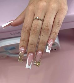 a woman's hand with pink and white manicures on her nails, next to an ironing board